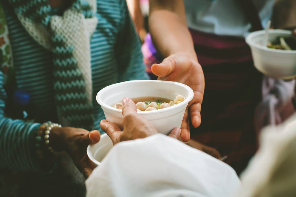 Los voluntarios dan comida a los pobres: concepto de comida de caridad para los pobres - Foto, imagen