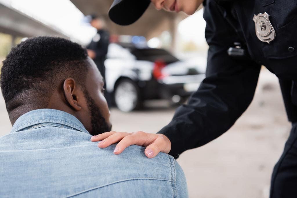 Poliziotta calmante vittima afro-americana sulla strada urbana  - Foto, immagini