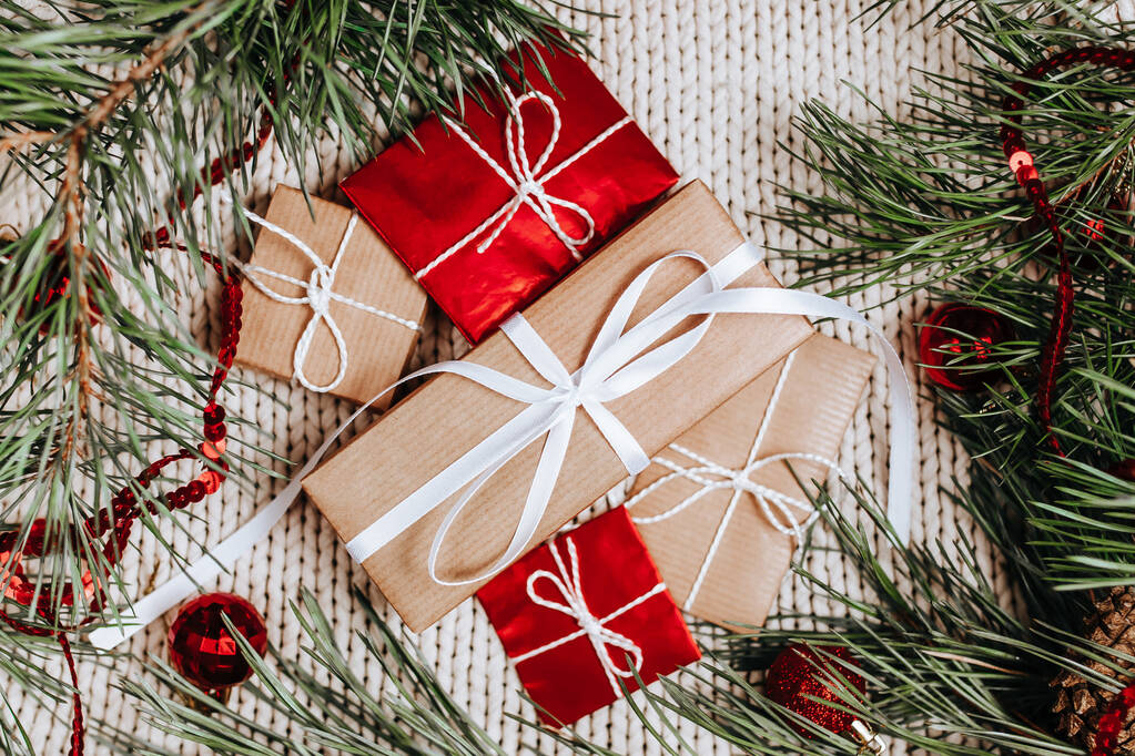 Πρωτοχρονιάτικα δώρα σε πλεκτό φόντο με χριστουγεννιάτικο δέντρο και παιχνίδια - Φωτογραφία, εικόνα