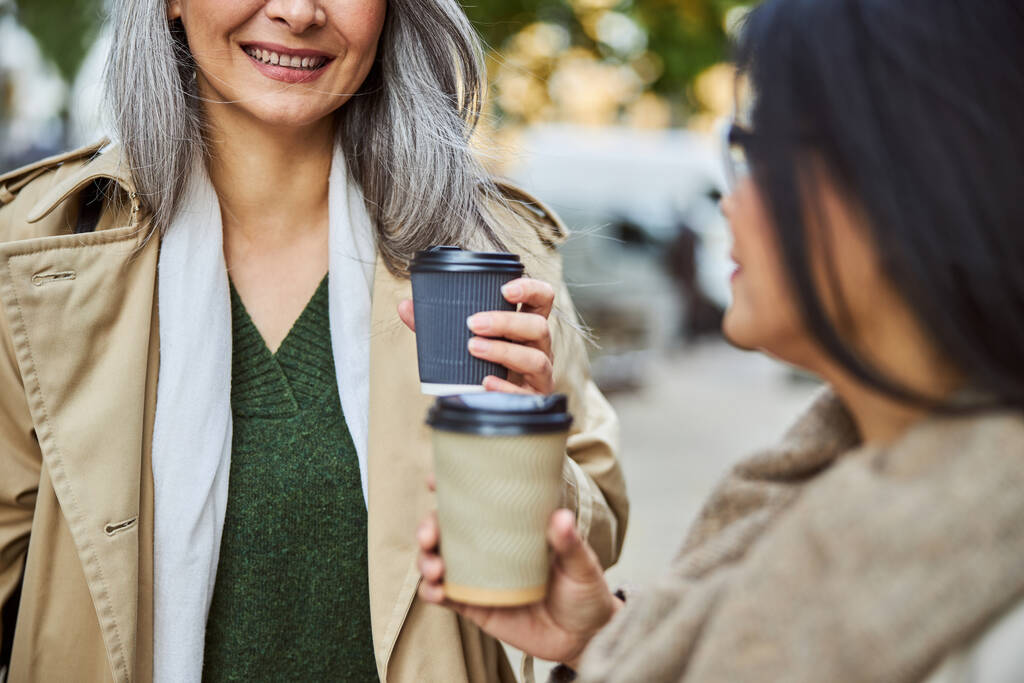 Iloiset naisystävät juomassa kahvia ja juttelemassa ulkona - Valokuva, kuva