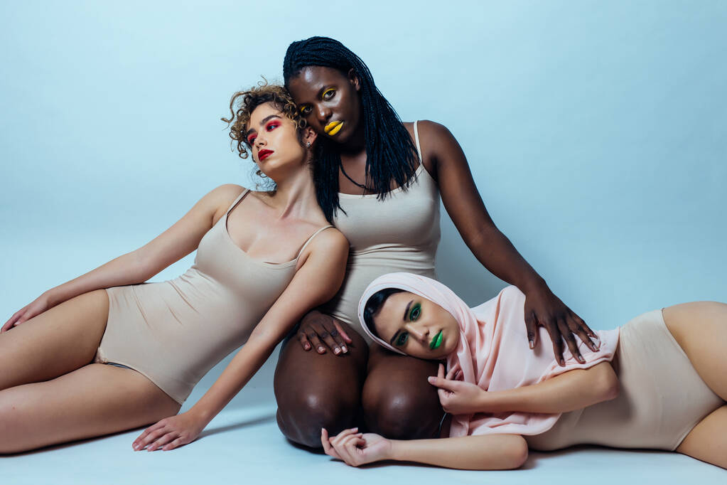 Trzy dziewczyny z różnych grup etnicznych pozujące w studio do sesji zdjęciowej "Pozytywność ciała" - Zdjęcie, obraz