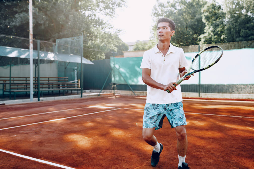 Fit mies pelaa tennistä tenniskentällä - Valokuva, kuva