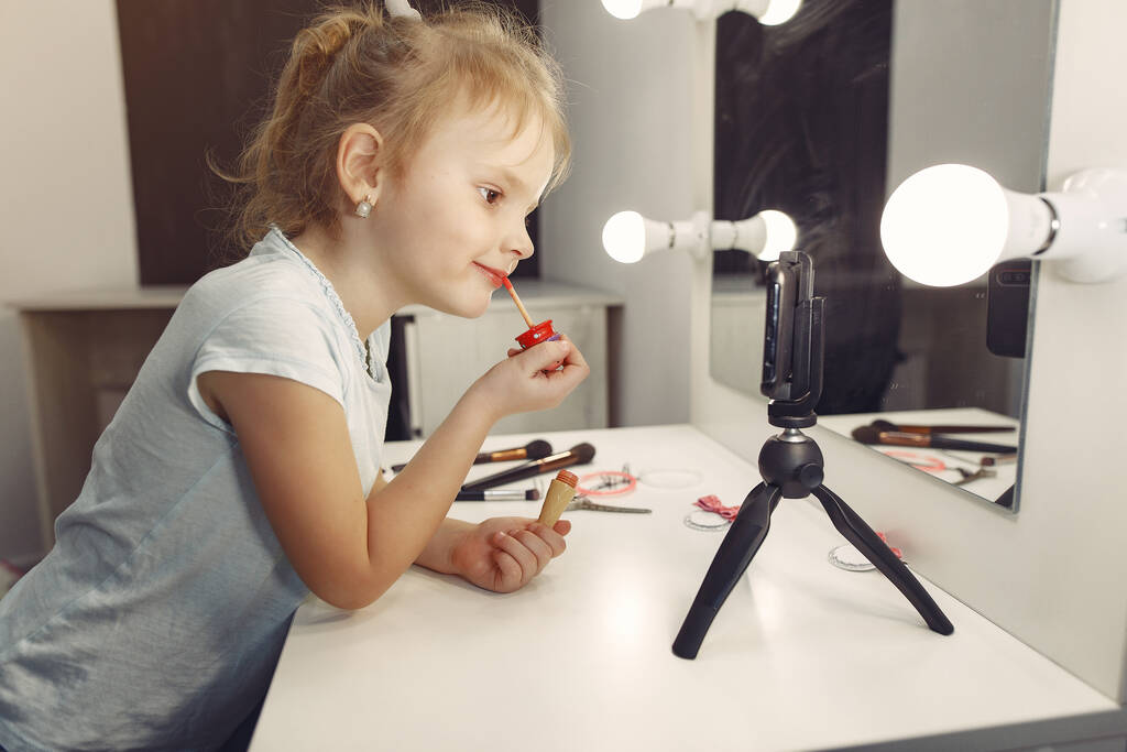 Carino piccolo blogger con cosmetici registrazione video a casa - Foto, immagini