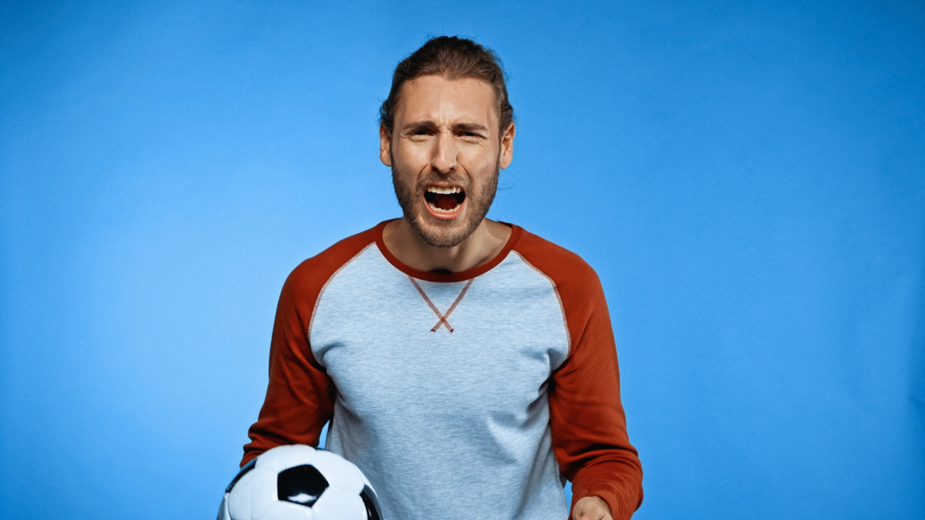 kibic piłki nożnej trzyma piłkę i krzyczy na niebiesko  - Zdjęcie, obraz