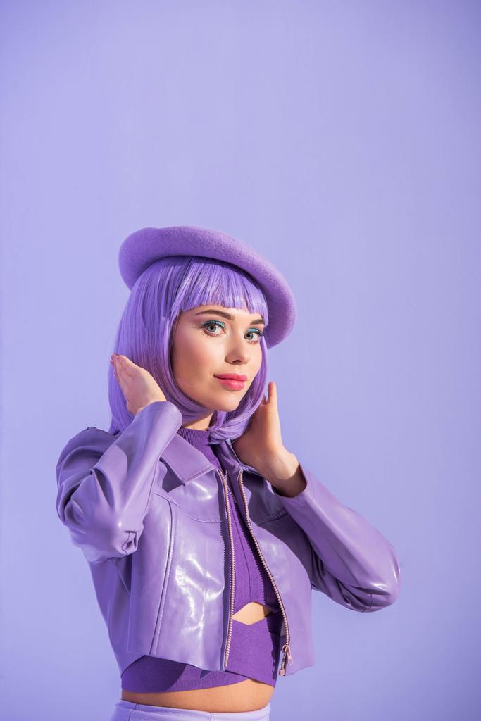 jonge vrouw gekleed in pop stijl in baret poseren op violette kleurrijke achtergrond - Foto, afbeelding