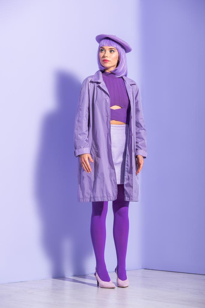 молода жінка, одягнена в ляльковий стиль в береті, позує на фіолетовому барвистому фоні
 - Фото, зображення
