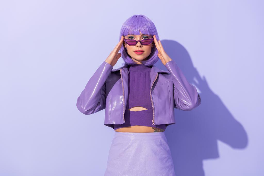 jonge vrouw gekleed in pop stijl op violette kleurrijke achtergrond - Foto, afbeelding