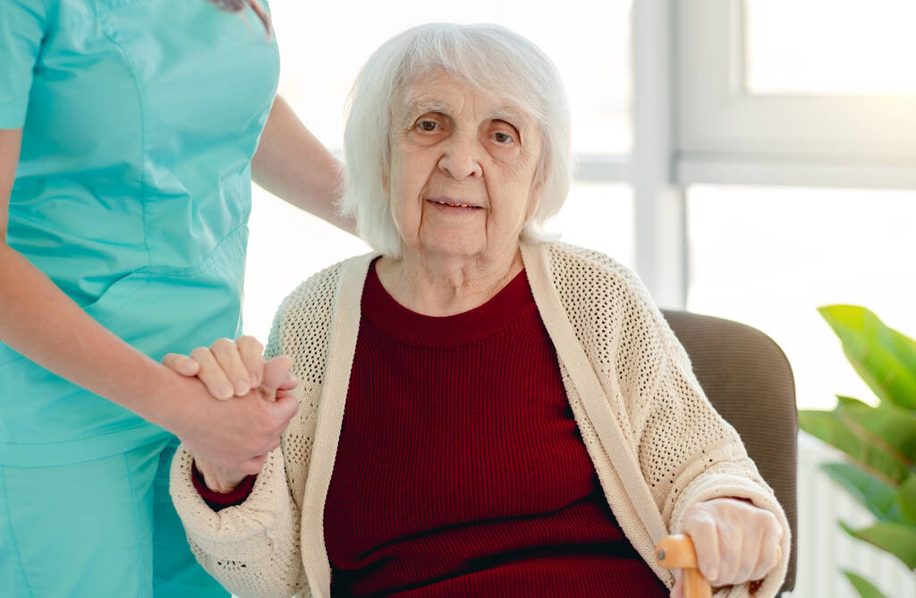 Stará dáma se opírá o ošetřovatelskou ruku - Fotografie, Obrázek