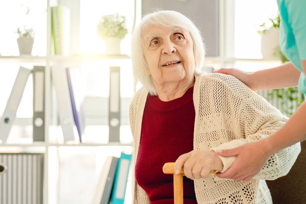 Mujer anciana en manos del cuidador - Foto, Imagen