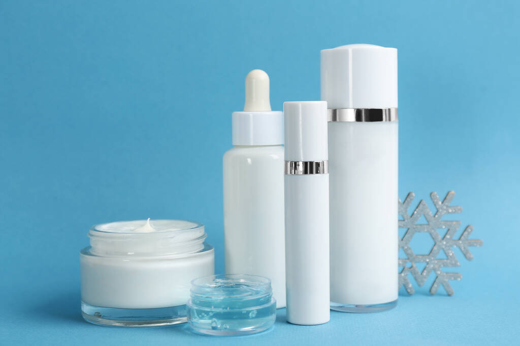 Schöne Komposition mit Kosmetikprodukten auf hellblauem Hintergrund. Winterpflege - Foto, Bild