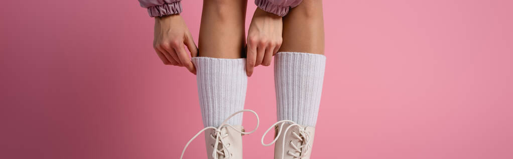ピンクの背景にブーツや靴下の女性の足のクロップドビュー、バナー - 写真・画像