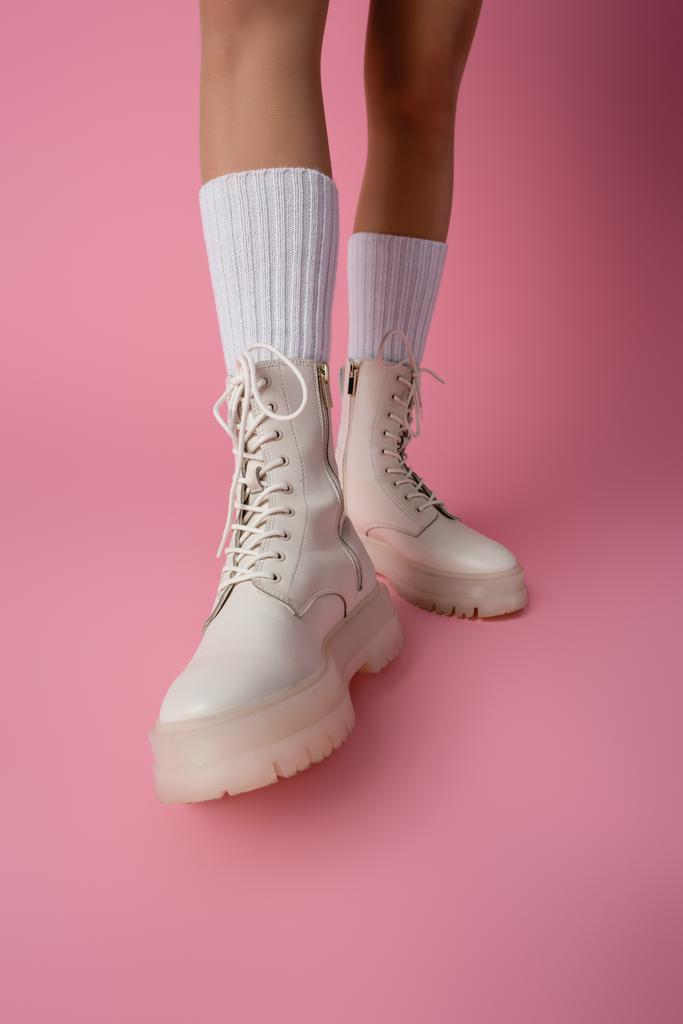 vista cortada de pernas femininas em botas e meias no fundo rosa - Foto, Imagem