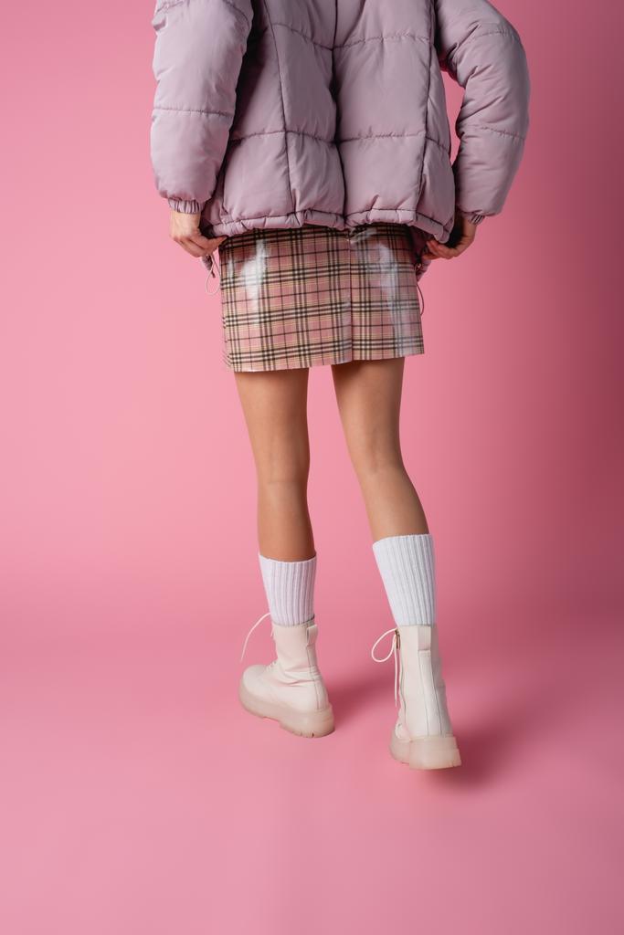 vissza kilátás fiatal nő stílusos téli ruha rózsaszín háttér - Fotó, kép