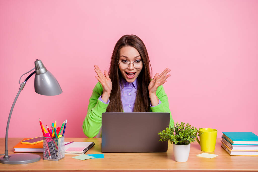 パートナーシップ契約。ショックを受けた女の子座ってテーブルルックノートパソコンの悲鳴を着て緑のシャツ孤立パステルカラーの背景 - 写真・画像
