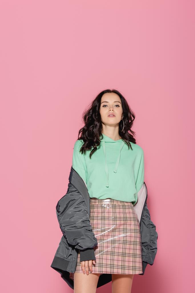 brunette young woman in casual winter outfit posing on pink background - Photo, Image