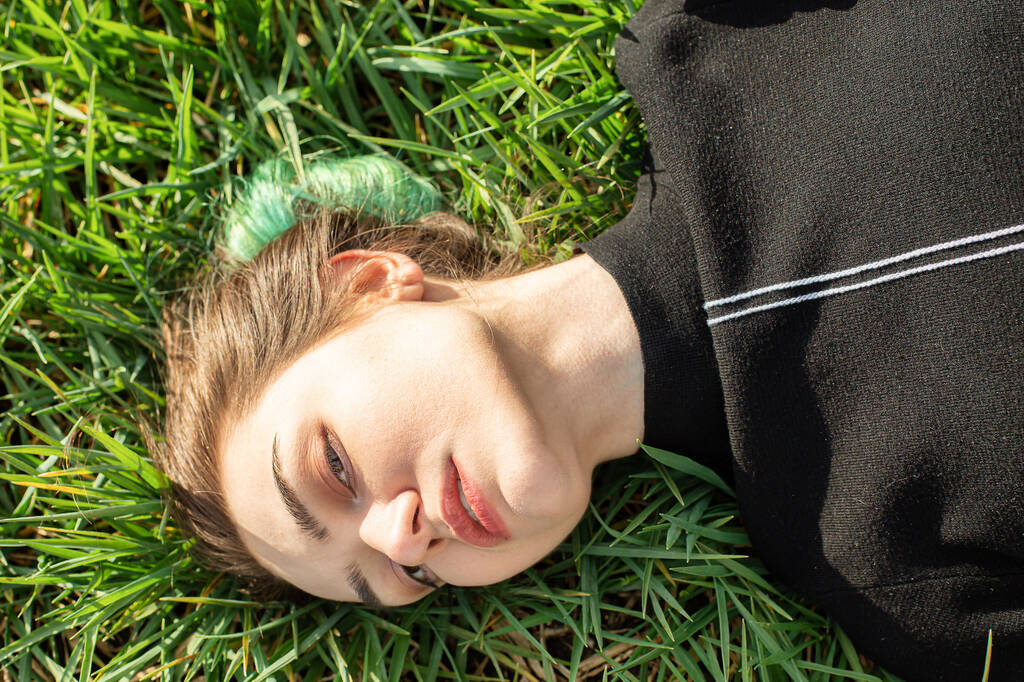 Emocjonalny portret białej dziewczyny na zielonej trawie - Zdjęcie, obraz