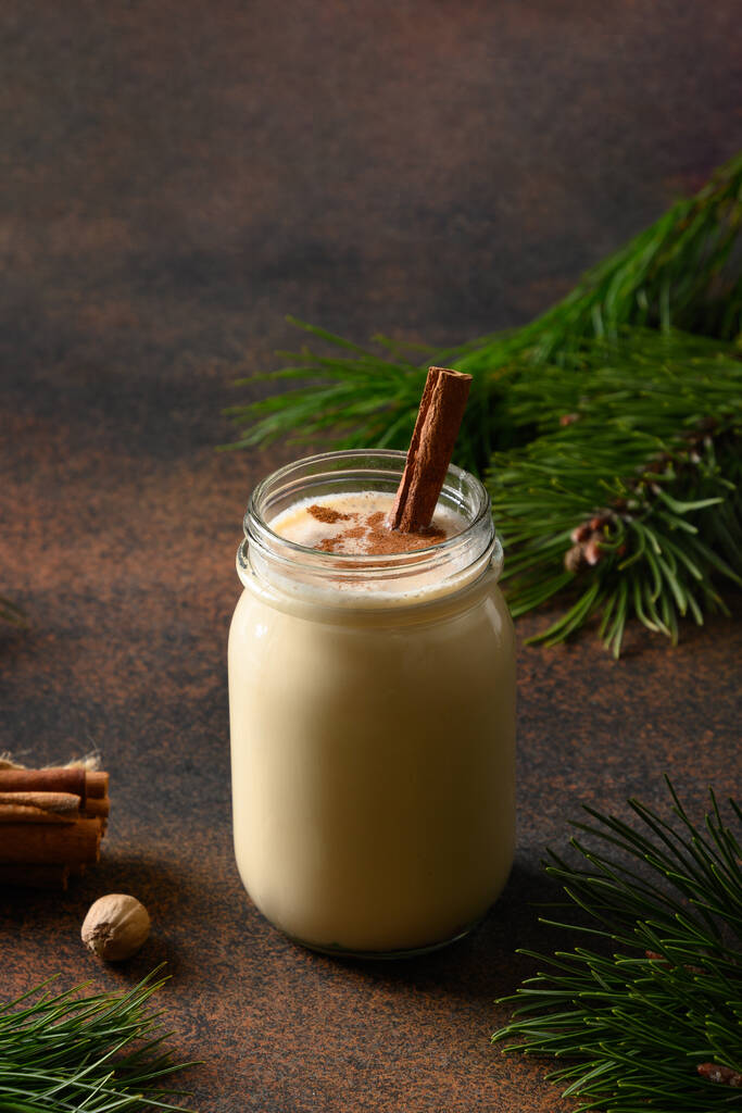 Holiday Christmas eggnog beverage in mason jar won brown background. Vertical format. Close up. - Photo, Image