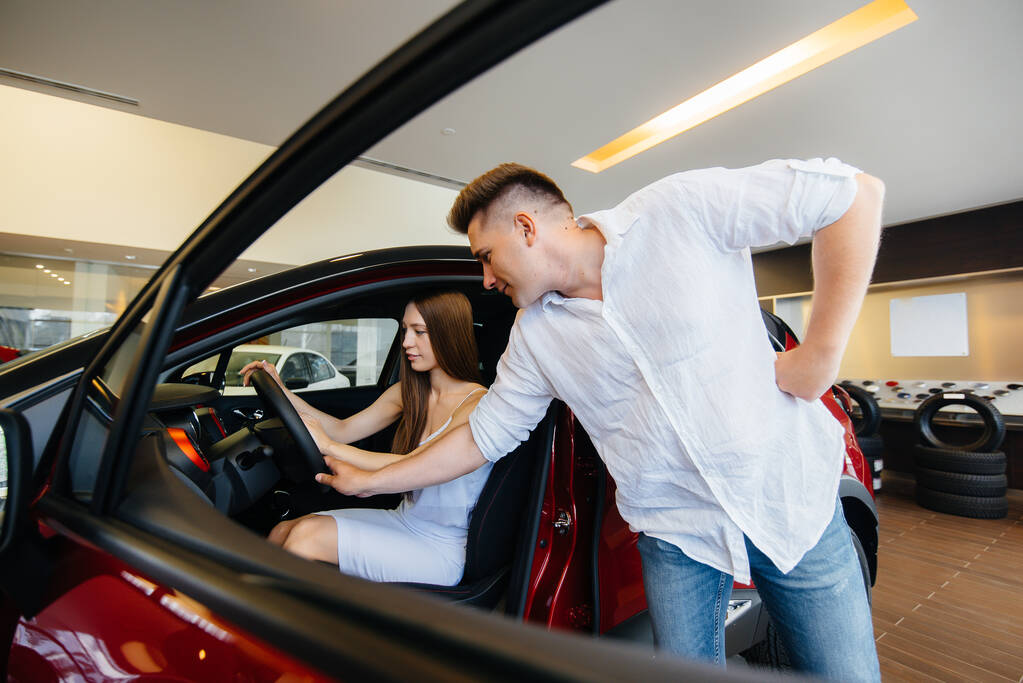 Šťastný mladý pár si vybere a koupí nové auto v prodejně aut. Koupě nového auta - Fotografie, Obrázek