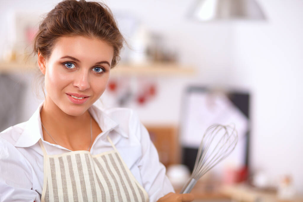 Улыбающаяся девушка, стоящая на кухне - Фото, изображение