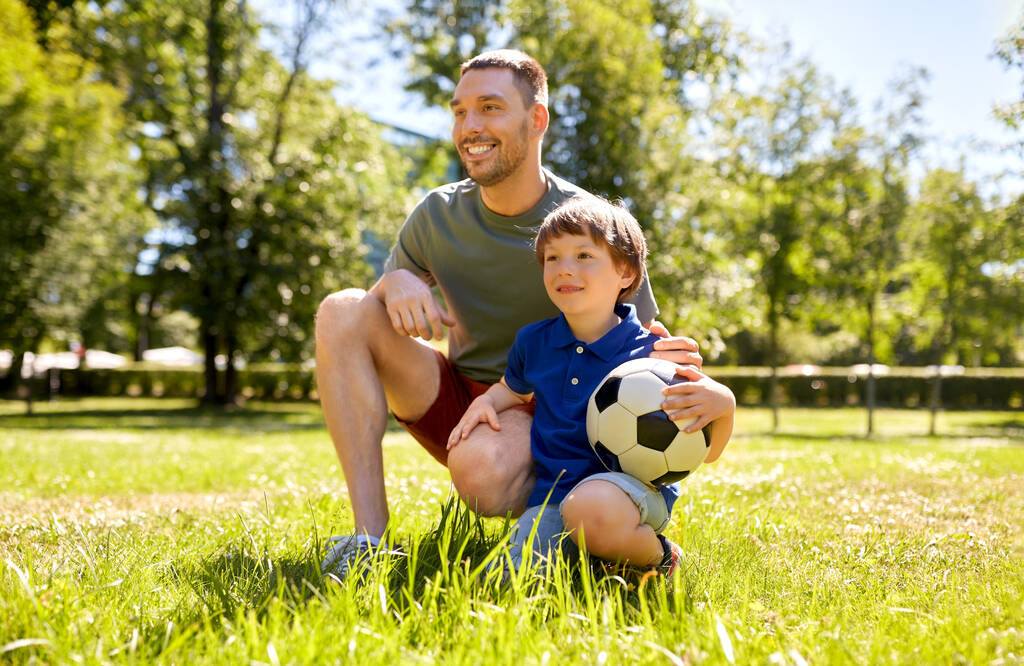 padre e hijo pequeño con pelota de fútbol en el parque - Foto, imagen
