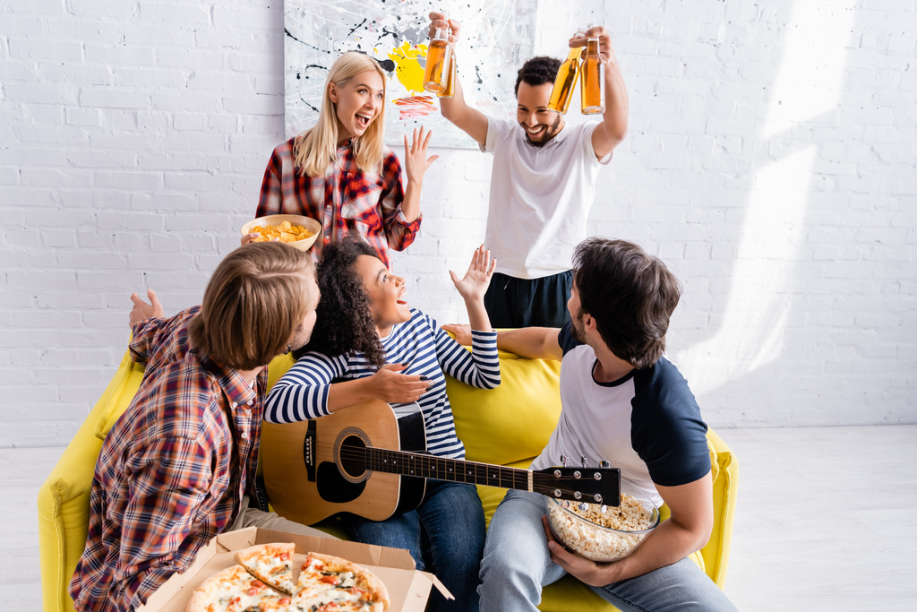 african american man holding beer near cheerful multiethnic friends during party - Photo, Image