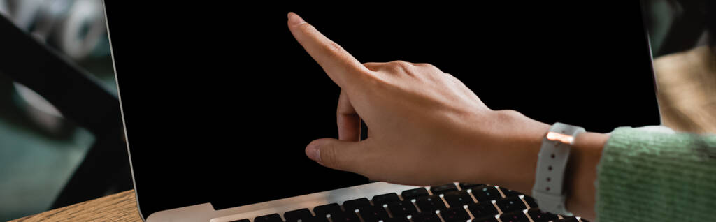 visão parcial da mulher americana africana apontando com o dedo para laptop com tela em branco, banner - Foto, Imagem