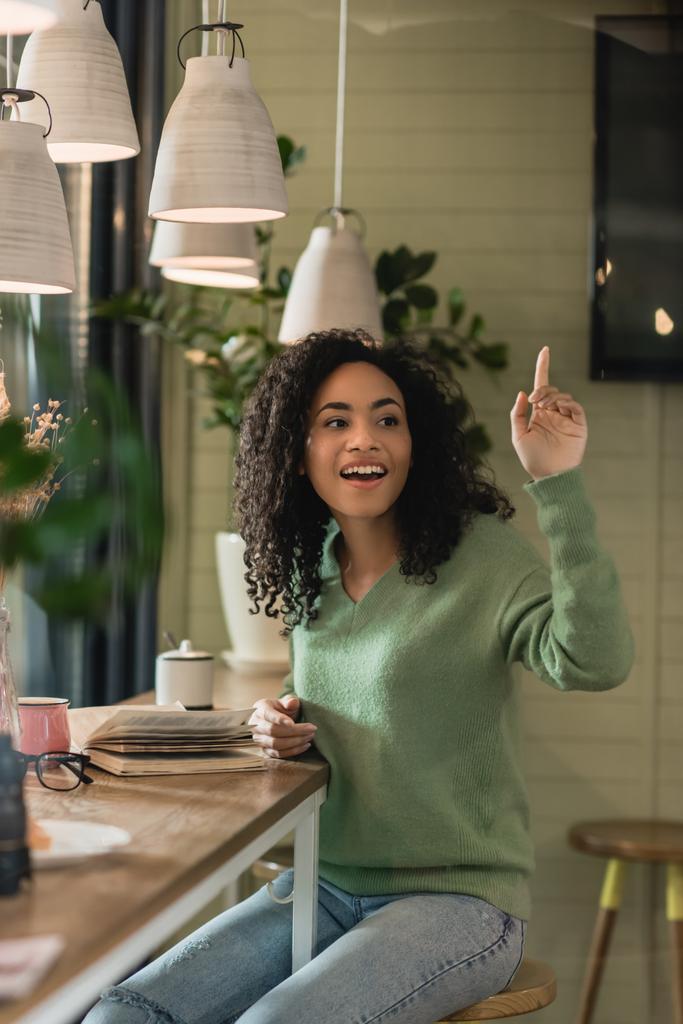 mujer afroamericana feliz gesto mientras pide factura en la cafetería - Foto, imagen