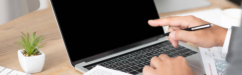 vista parziale di uomo d'affari che punta con il dito al computer portatile, banner - Foto, immagini