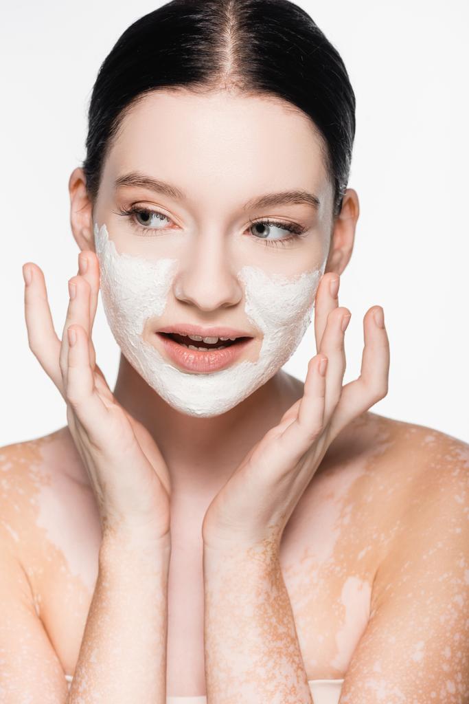jeune belle femme avec vitiligo et masque d'argile sur le visage isolé sur blanc - Photo, image