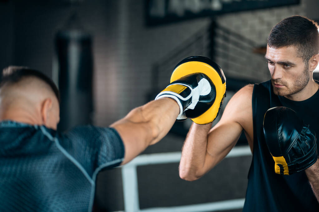 zwei Muskel-Boxer trainieren und kämpfen auf dem Boxring im Fitnessstudio - Foto, Bild