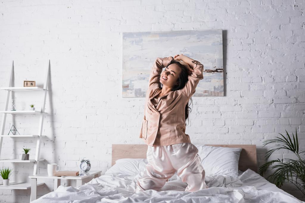 若いブルネットの女性を笑顔でベッドで朝 - 写真・画像