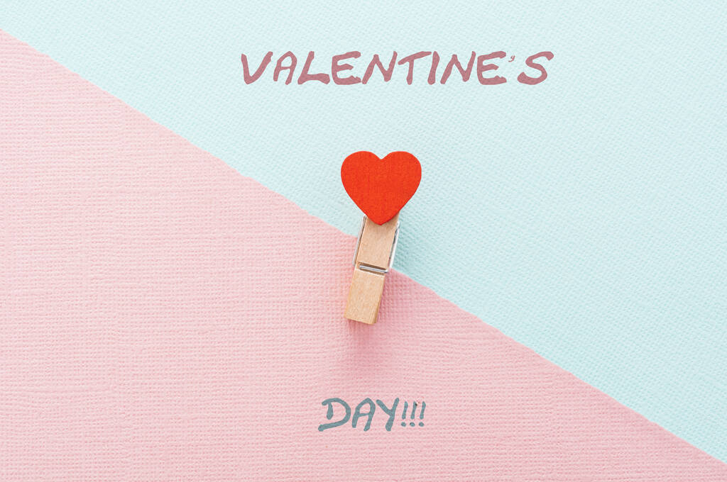 Felizes cumprimentos do Dia dos Namorados. Em um contexto rosa e azul, um clothespin com um coração e a inscrição feliz Dia dos Namorados. - Foto, Imagem