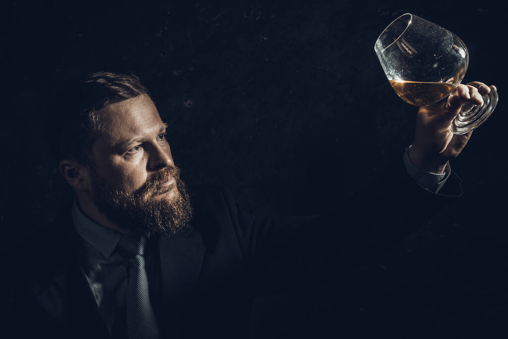 Solide homme barbu confiant en costume avec verre de whisky - Photo, image