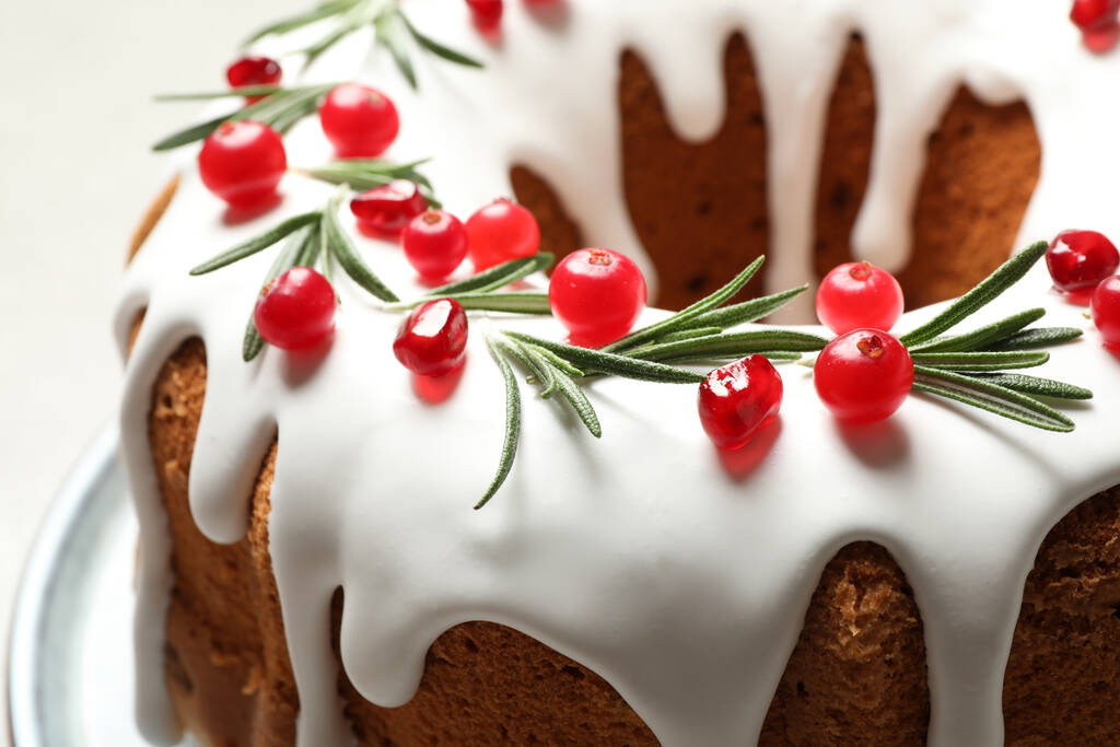 Tradiční vánoční dort zdobený glazurou, granátovými semínky, brusinkami a rozmarýnem na stole, detailní záběr - Fotografie, Obrázek