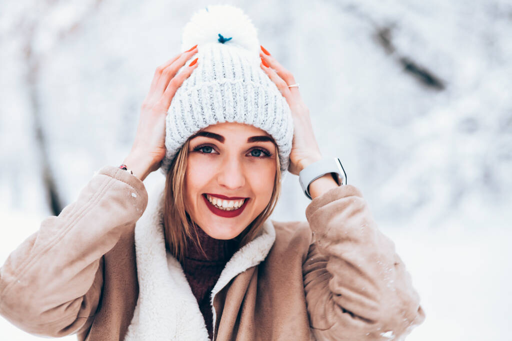 冬のスノーパークで帽子をかぶった若い女性が - 写真・画像
