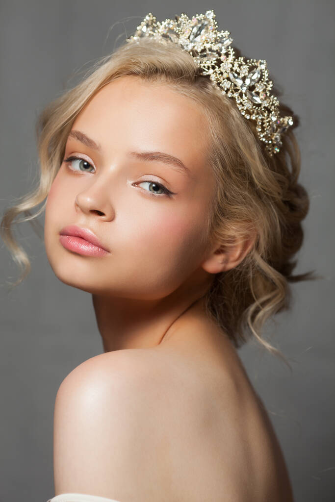 Beautiful blond woman in the image of a bride with a tiara in her hair. Picture taken in the studio on a gray background. Beauty baby face. Wedding image. - Photo, Image