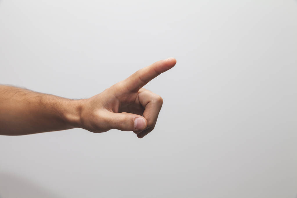 A closeup shot of a hand pointing on something on white background - Photo, Image