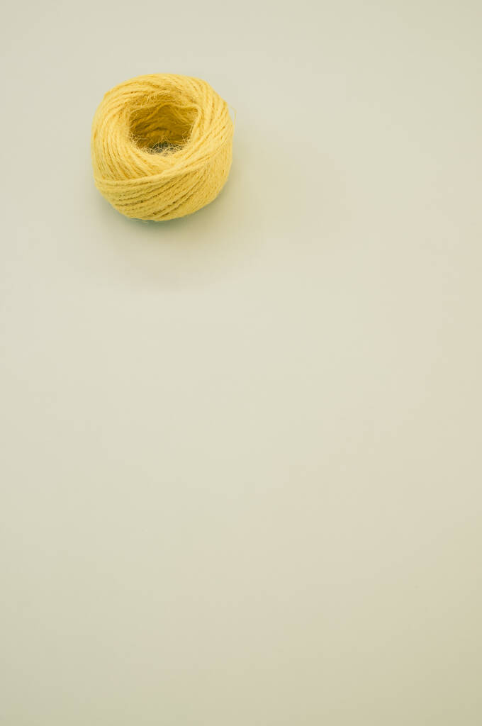 Жовта кулька з пряжі для в'язання ізольована на сірому фоні
 - Фото, зображення