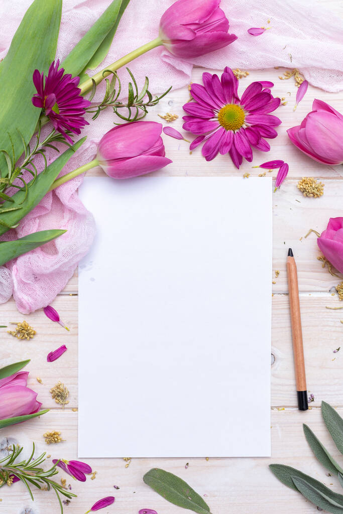Eine Draufsicht auf ein leeres Papier und einen Bleistift mit lila Blumen - Foto, Bild