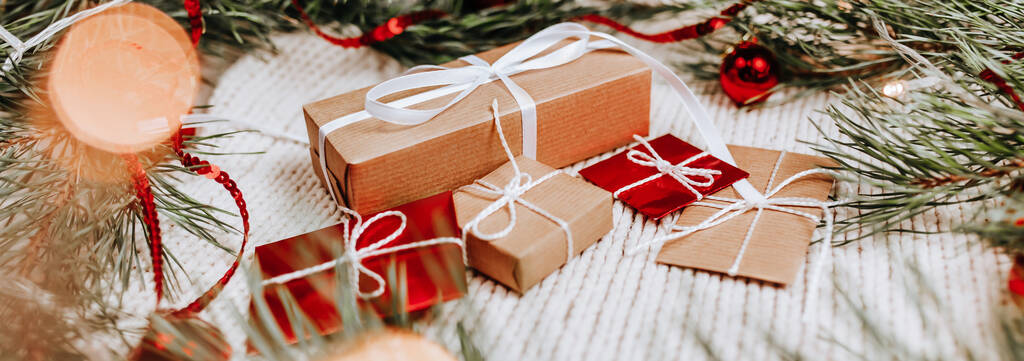 Újévi ajándékok kötött háttér karácsonyfa és játékok a fények - Fotó, kép