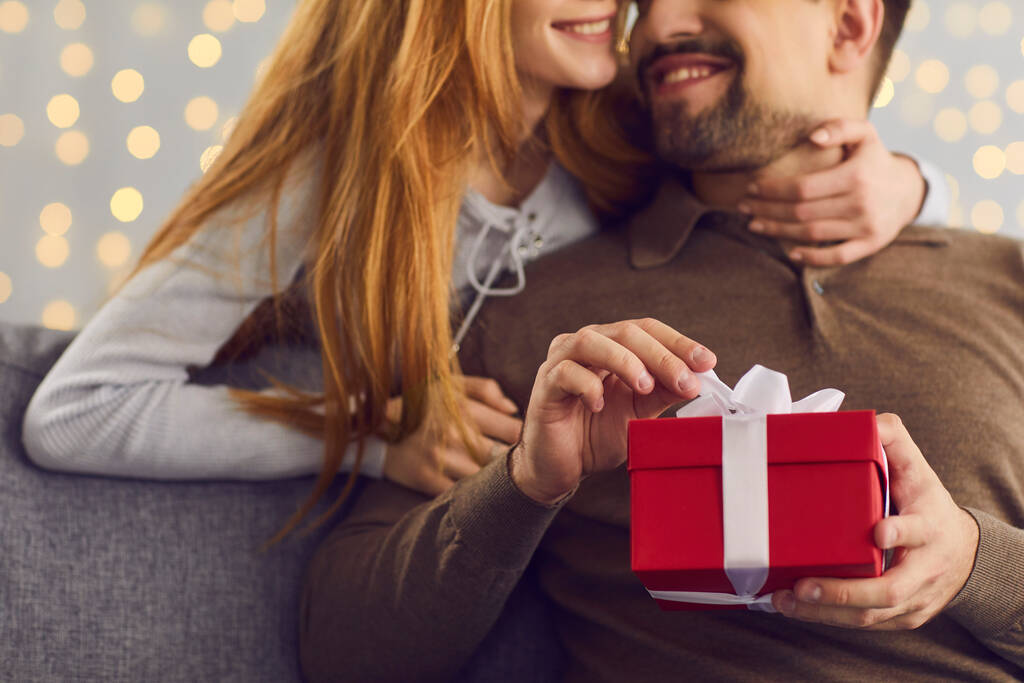Sevgilisini kucaklayan gülümseyen bir kadın sevgilisinin hediyesini ya da doğum günü hediyesini açar. - Fotoğraf, Görsel