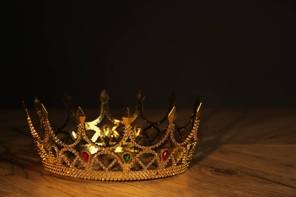 Prachtige gouden kroon met edelstenen op houten tafel. Fantasie item - Foto, afbeelding