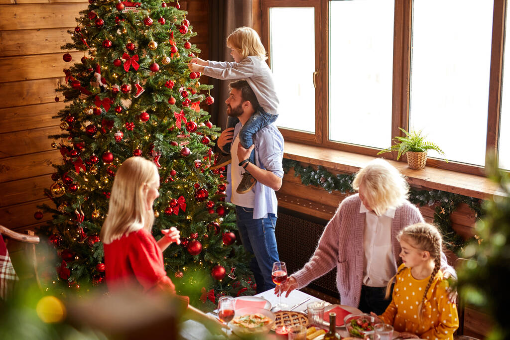 ευτυχισμένη οικογένεια διακόσμηση χριστουγεννιάτικο δέντρο στο σαλόνι - Φωτογραφία, εικόνα