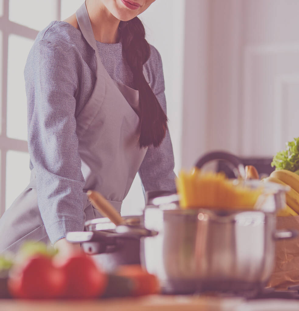 Young woman holding grocery shopping bag with vegetables .Standing in the kitchen - Photo, Image