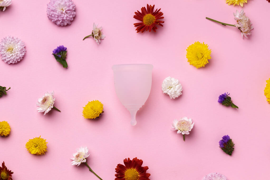 Puchar menstruacyjny na kwiatowy wzór tła widok z góry - Zdjęcie, obraz