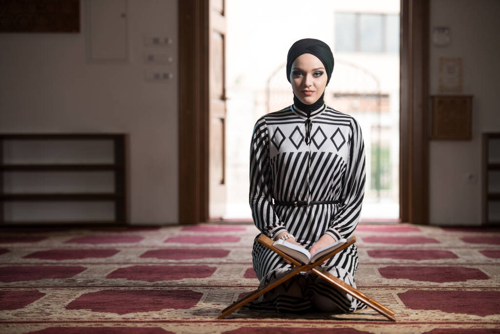 Jonge moslimvrouw biddend in moskee - Foto, afbeelding