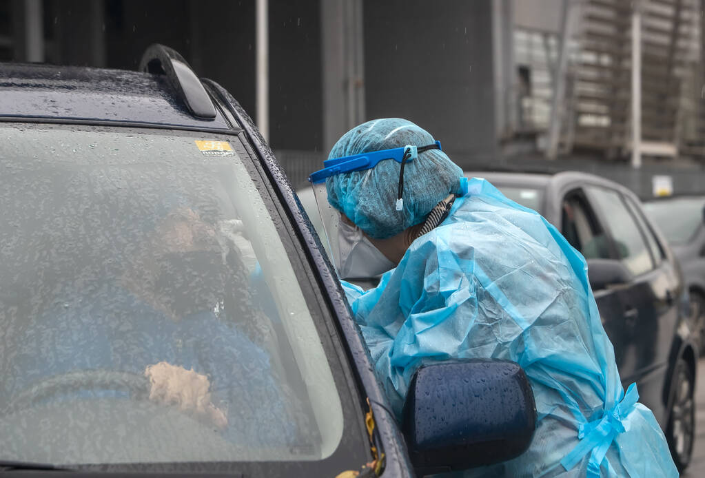 Salónica, Grécia - 10 de Dezembro de 2020. Um trabalhador médico vestindo terno especial para proteger contra coronavírus, realizar um "drive through" testes rápidos para covid-19 - Foto, Imagem