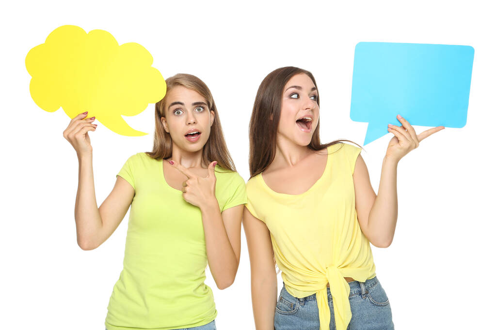 Fiatal boldog barátnők papír beszéd buborékok fehér háttér - Fotó, kép