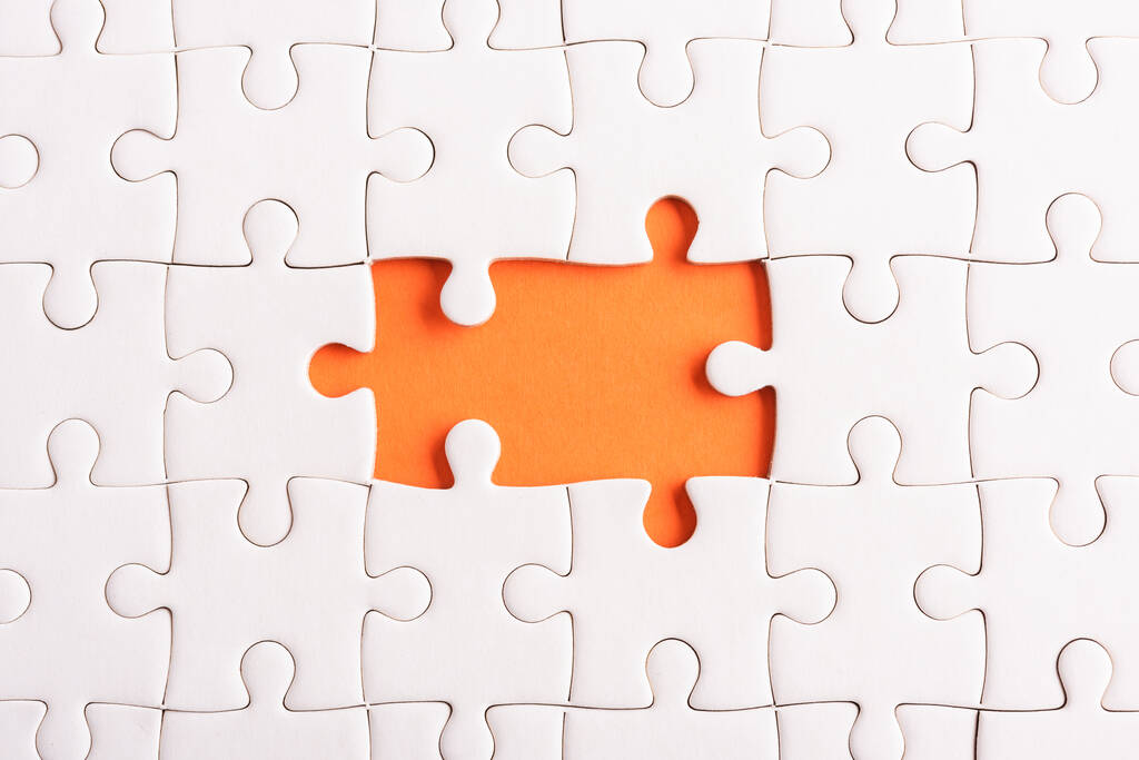 Draufsicht flache Lage aus Papier schlicht weiße Puzzle-Spieltextur unvollständiges oder fehlendes Stück, Studioaufnahme auf orangefarbenem Hintergrund, Quizberechnungskonzept - Foto, Bild