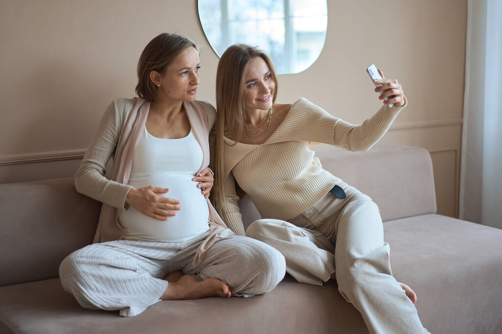 Pareja lesbiana esperando al bebé, mujer posando con su novia embarazada - Foto, imagen